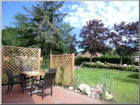 Sichtgeschützte Terrasse mit Steinbrunnen und Strandkorb