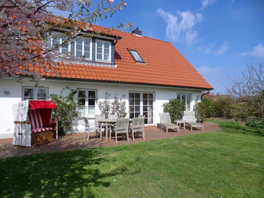 Sonnige Südterrasse mit Gartenmöbeln, Strandkorb und Liegen