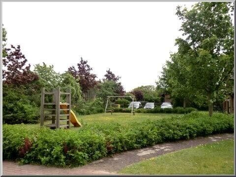 Blick über den kleinen Kinderspielplatz zu den Pkw-Stellplätzen