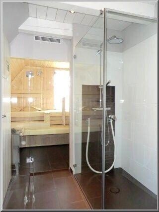 Duschbereich u.a. mit Rainshower und dahinter liegender Sauna